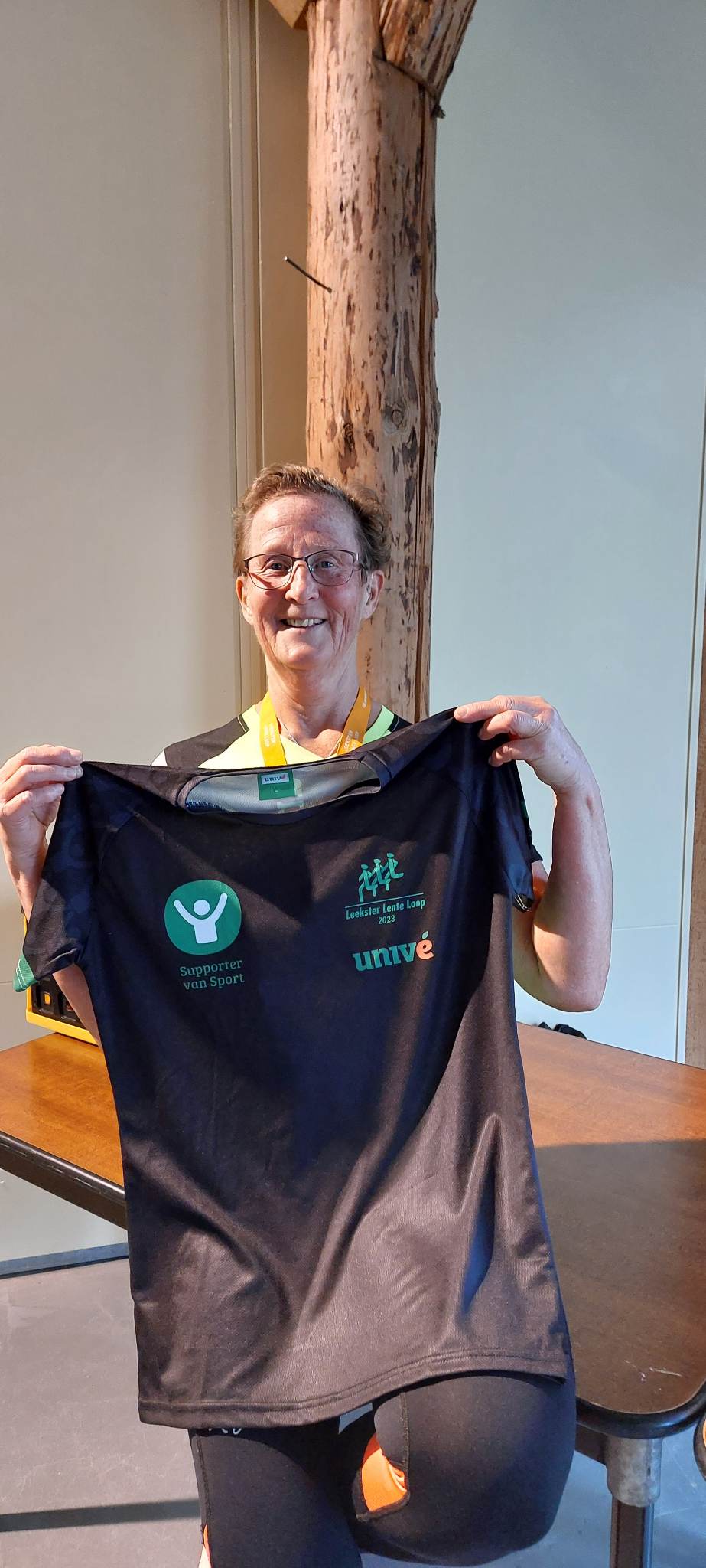 Vrouw houdt een T-shirt omhoog.